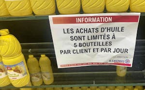 Une affiche indiquant aux clients d'un supermarché qu'ils ne peuvent pas achetées plus de 5 bouteilles d'huile par client et par jour.